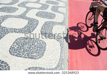 Ipanema Beach Rio de Janeiro boardwalk pattern with cyclist shadow on stretch of red bike path