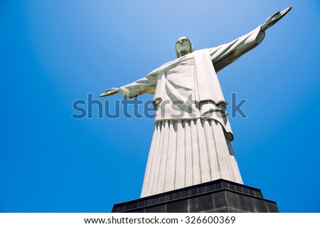 RIO DE JANEIRO, BRAZIL - OCTOBER 20, 2013: Statue of Christ the Redeemer stands on its base at the top of Corcovado Mountain against clear blue sky.