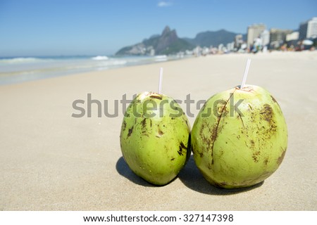 Two green coconuts on Ipanema Beach against a backdrop of Two Brothers Mountain in Rio de Janeiro Brazil