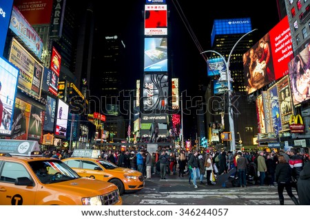 NEW YORK, USA - DECEMBER 27, 2014: Yellow New York taxis pass crowds gathering under the bright lights of Times Square in the build-up to New Year\'s Eve.