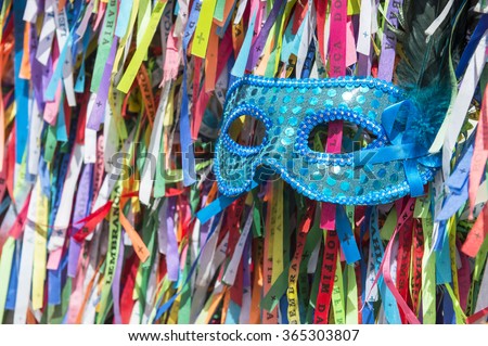 Blue sequined carnival mask in a background of Brazilian wish ribbons Salvador Bahia Brazil