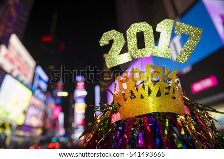 Glittery 2017 Happy New Year message with celebration tinsel flying on novelty party hat in Times Square, New York City