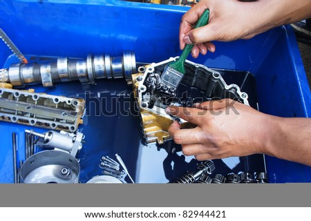 a mechanic cleaning the mechanical parts from automotive vehicle