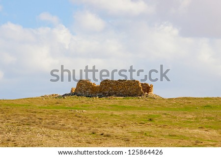 Ruined house in a desert under a clouds