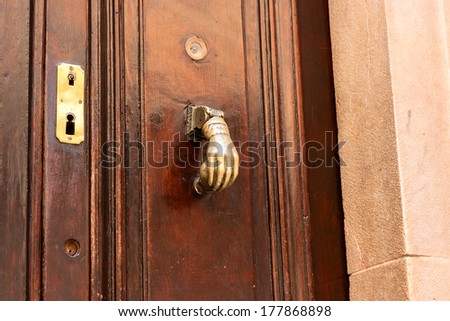 Bronze hand on brown wood door