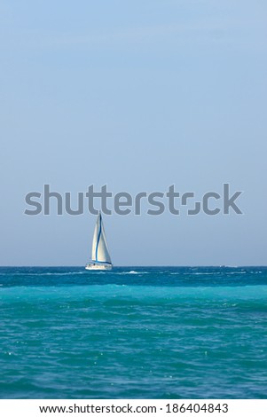 Small yacht with white sail on Mediterranean Sea
