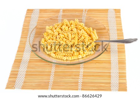 Macaroni in a transparent plate on straw mat isolated on white background
