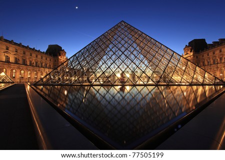 PARIS - APRIL 07: Louvre Pyramid shines at dusk on April 07, 2011 in Paris. Louvre is the biggest Museum in Paris and displays over 60,000 square meters of exhibition space.