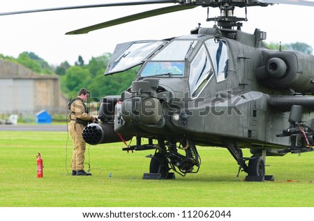 COSFORD, SHROPSHIRE, ENGLAND - JUNE 17: Unidentified ground crew preparing AH-64 Apache helicopter for flight at RAF Cosford airshow on June 17, 2012 in Cosford, Shropshire, England.