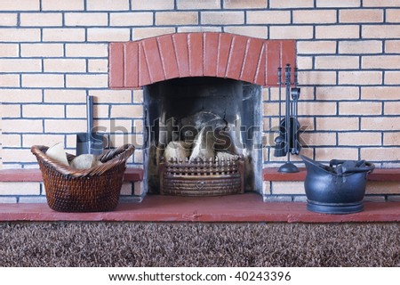 Coal bucket and tools on red brick hearth