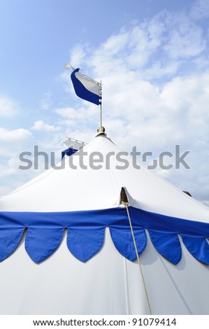 Large blue and white medieval tent against blue sky