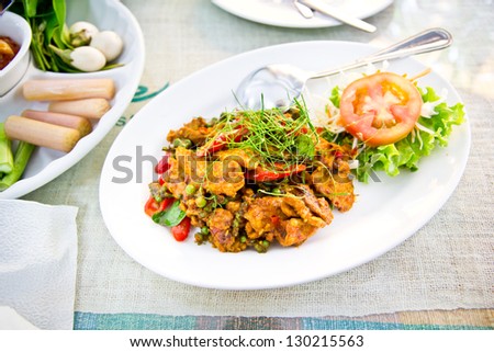 Dried pork with spicy curry on white plate in restaurant