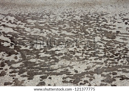 Spots of black tar on the gray asphalt as a texture