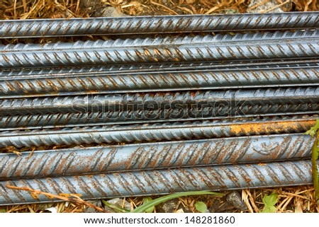 Group of parallel ribbed reinforcement rods lying on the ground