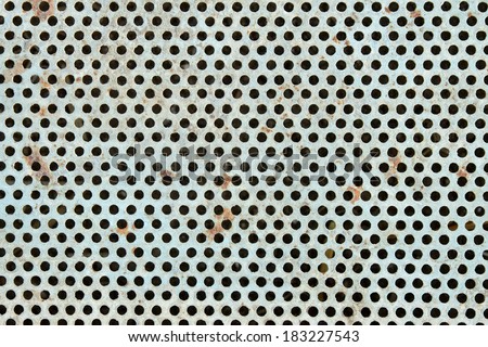 Old metal grate with round holes painted in light blue as a texture