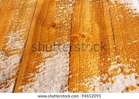 Wooden shield with new lacquered planks covered with snow