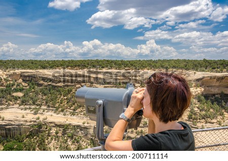 Young Woman Looking at the Scenery Through a Telescope