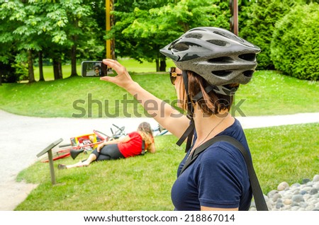 Young Woman Cyclist Taking a Selfie in a Park
