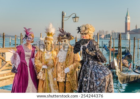 Venice, Italy - February 11, 2015: People Wearing Traditional Costumes at the Carnival of Venice. It is common for people to attend the Venetian Carnival wearing elaborate costumes, plus masks.