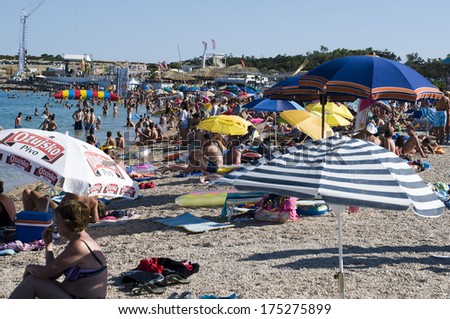CROATIA, PAG Island - AUGUST 5, 2011: Big crowd of swimmers on a hot summer day on Zrce beach, Novalja, Pag island, Croatia, Adriatic sea. Zrce beach is the most popular party beach in Adriatic sea