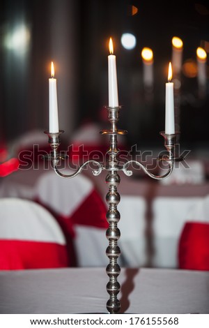Candle holder with white candles lit in a restaurant