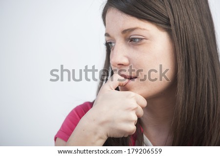 Closeup portrait of a stressed young woman biting her nails