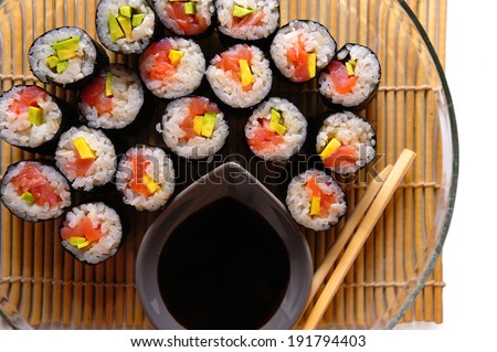 Sushi rolls on a plate with chopsticks and soy sauce, top view