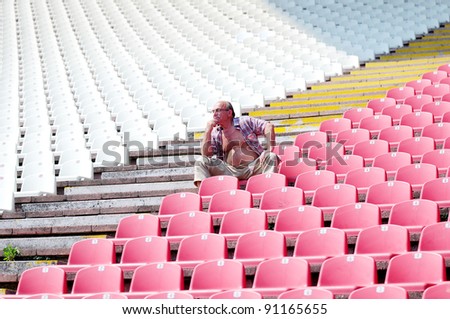 Man sitting alone in an empty stadium