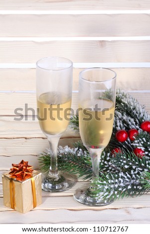 Christmas (New Year\'s) glasses with sparkling (white wine) against a fir tree branch