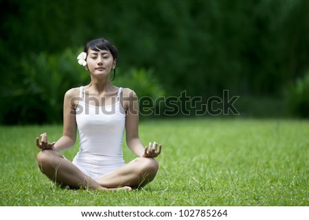 Asian woman in yoga position shot outdoor during summer