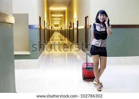 Asian woman chatting on the phone shot in a 5 stars hotel aisle