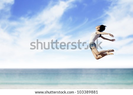 Asian woman flying at the beach. Copy space available for your own text