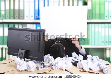 Hopeless businessman holding white banner, shot in office with many waste paper