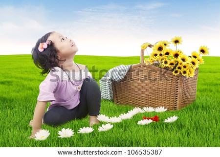 Cute asian girl with basket of sunflowers. shot outdoor