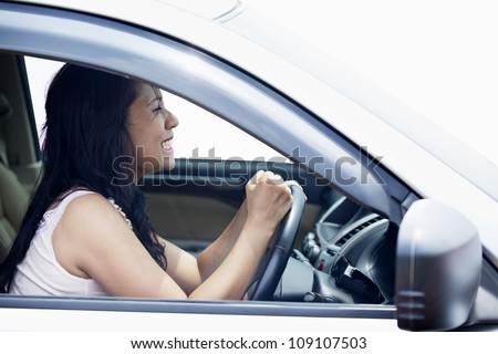 Closeup of a female driver angry punching the steering wheel
