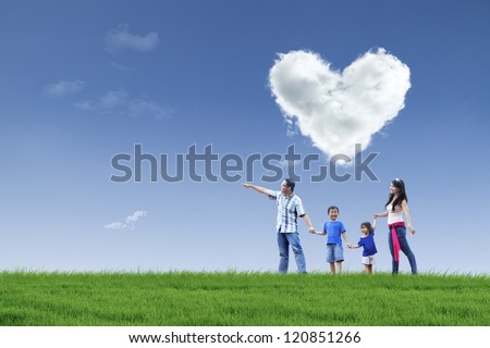Happy Family Walking In The Park With Cloud Of Love In The Sky