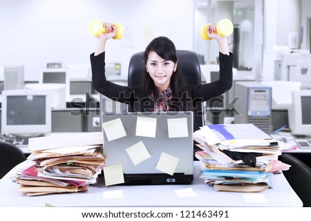 Young businesswoman doing exercise in front of her laptop with lots of sticky notes