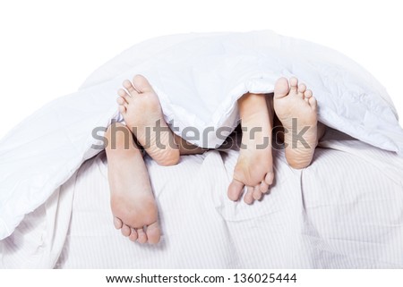 Close-up of the feet couple in bed