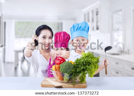 Happy kids chef with their mother  preparing vegetable at home