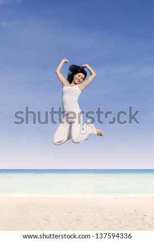 Beautiful Asian woman jump at beach