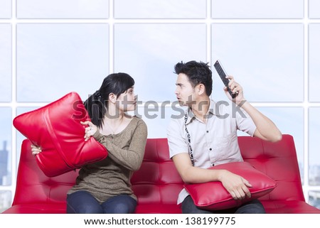 Couple fight on red sofa in apartment