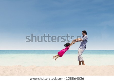 Father lifting her daughter on the beach Father lifting her daughter on the beach