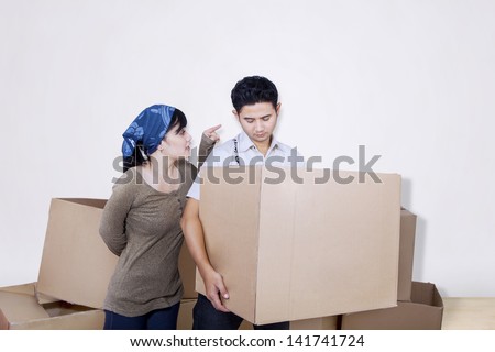 Boyfriend bring box on white with angry girlfriend, shot at studio