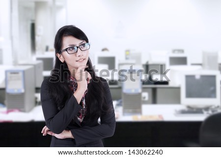 Asian Business woman with arms folded, thinking of something at the office