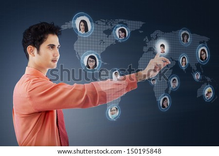 Asian businessman clicking on social networking map over blue digital world map