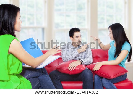 Couple arguing during therapy session with psychologist