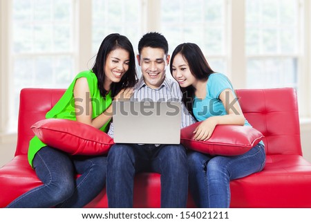 Three young friends studying with laptop at home