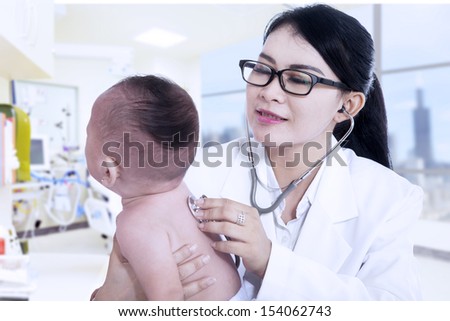 Asian children's doctor exams a baby with stethoscope at clinic
