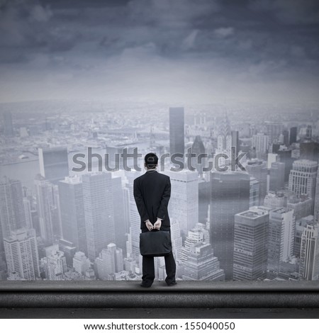 Portrait of a businessman looking into the future standing on the top of a skyscraper