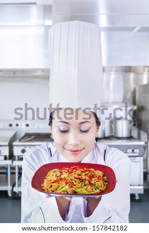 Asian chef serve noodle in the kitchen